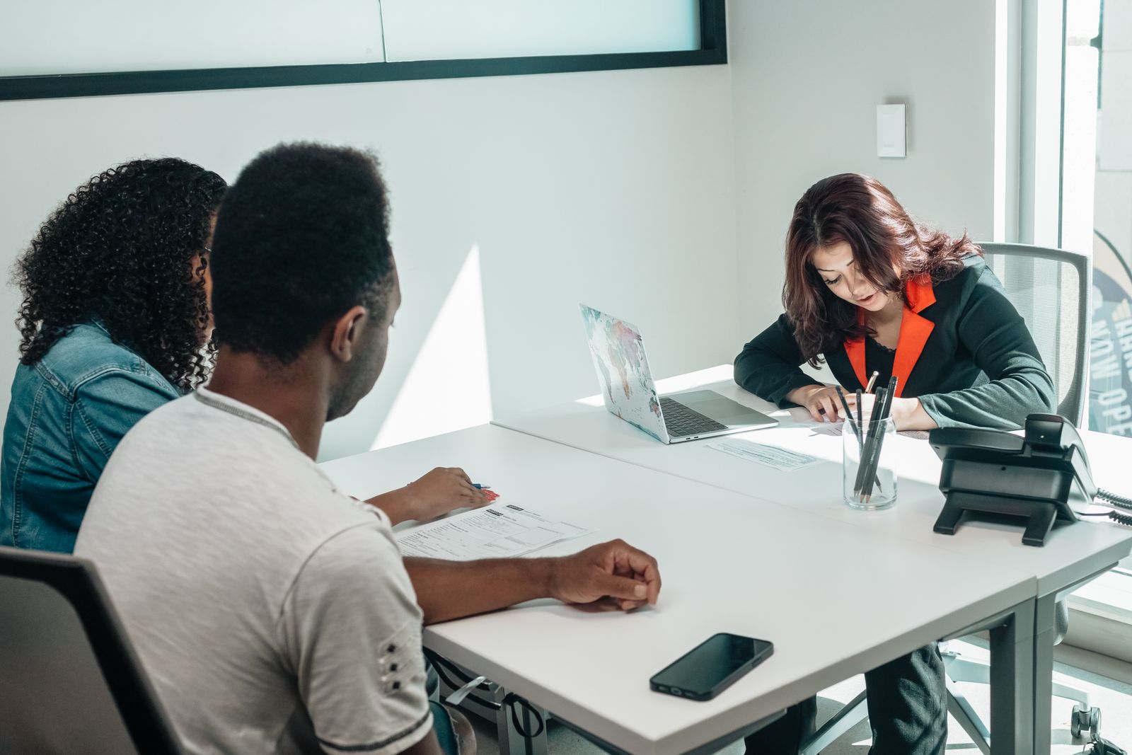 Couple discussing paperwork with an advisor
