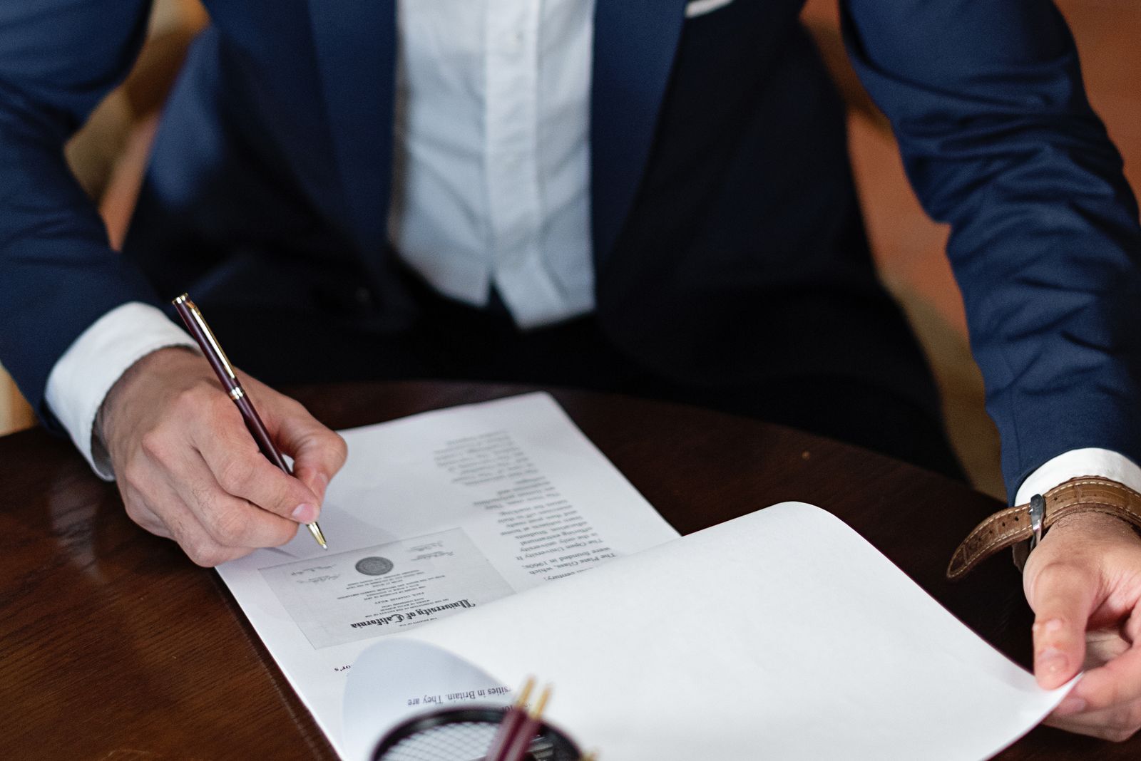 Person signing a document at a desk